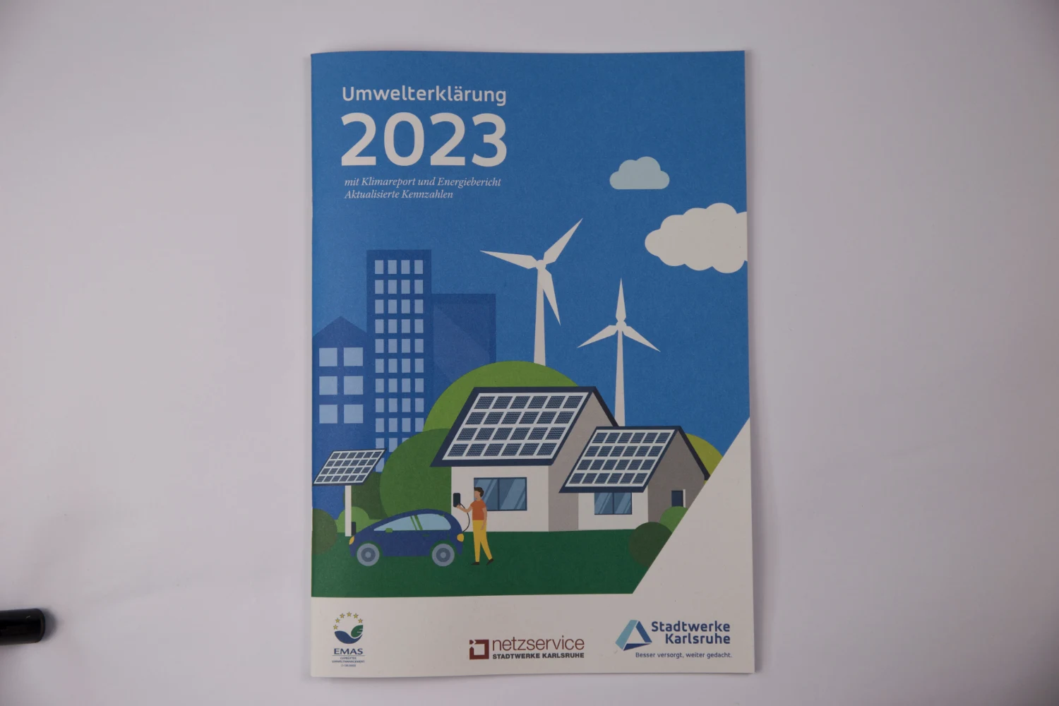 Umwelterklärung 2023 der Stadtwerke Karlsruhe mit blauem Umschlag und Illustrationen erneuerbarer Energien
