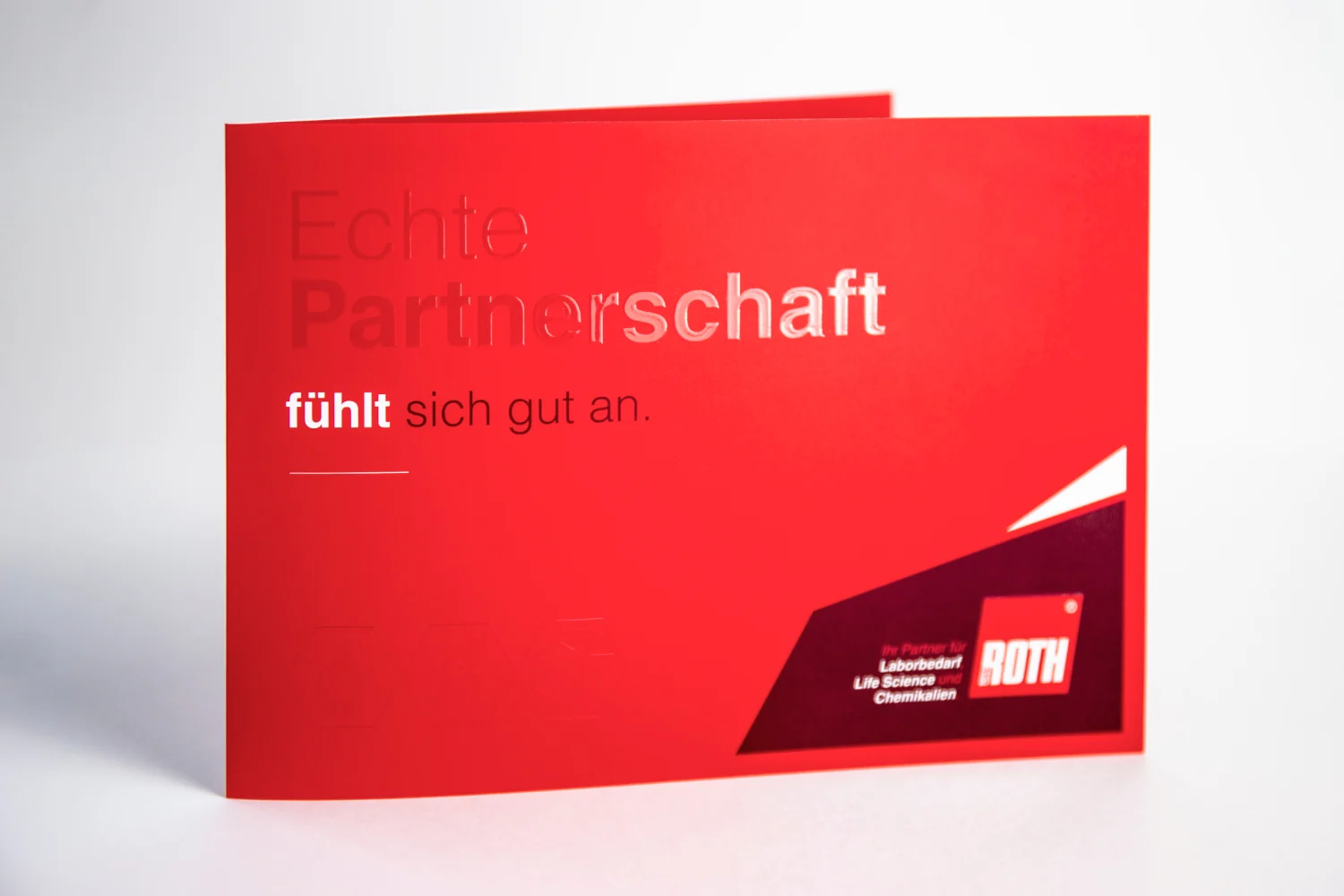 Rotes Faltmailing mit glänzender erhabener Schrift