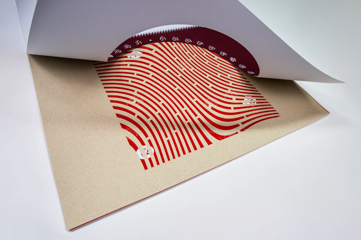 Naturfarbene Kalenderseite mit gestanztem Linienmotiv und umgeblättertem Deckblatt