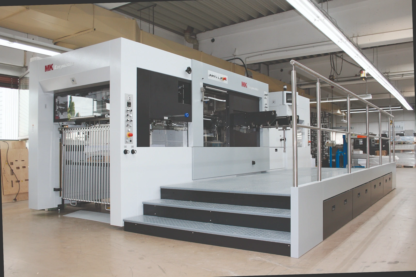Blick in eine Produktionshalle mit einer großen Maschine zur Druckweiterverarbeitung